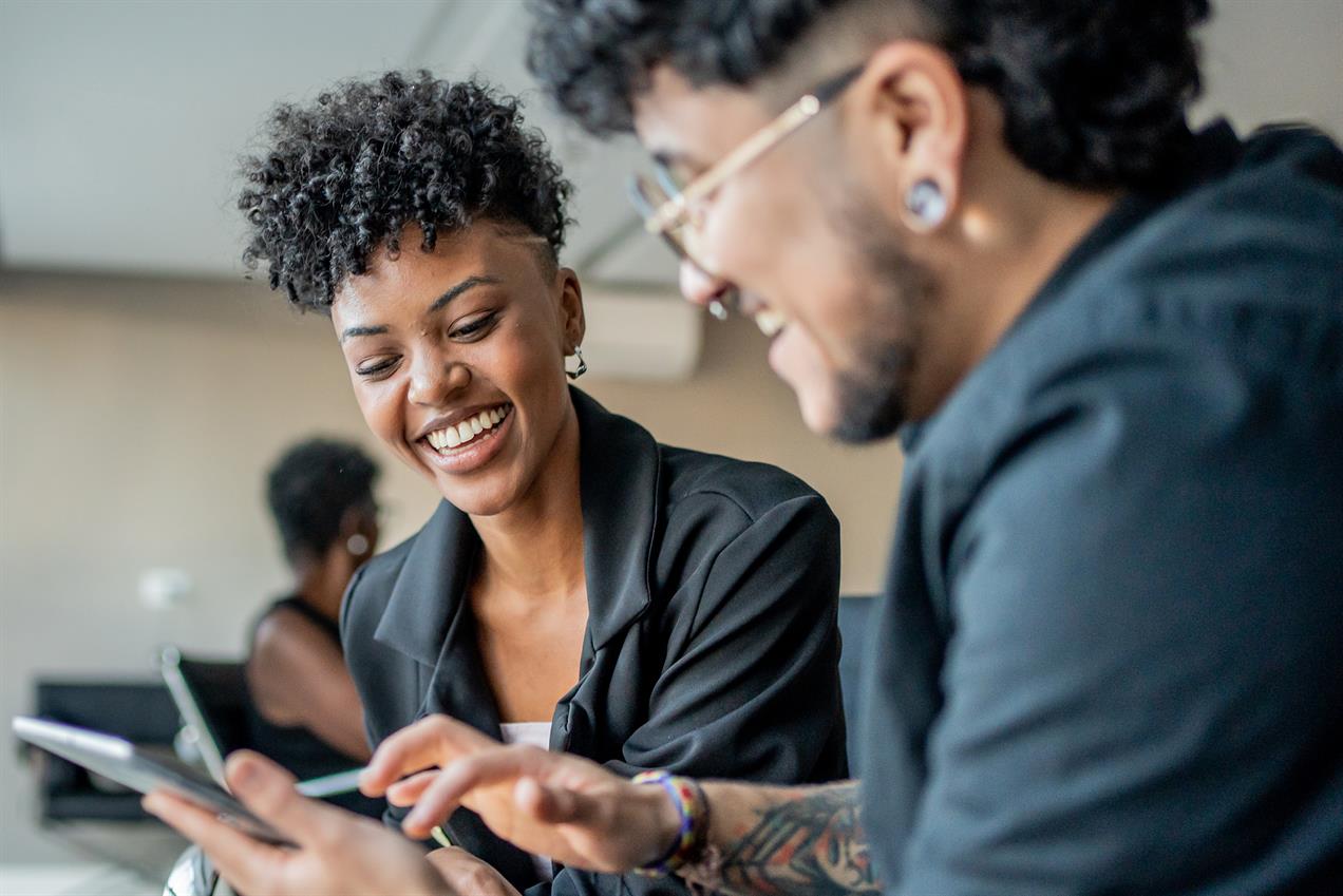 two workers smiling over a tablet