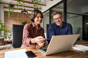 Two colleagues discussing in front of laptop