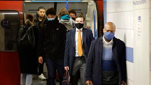 Commuters with face masks stepping off the tube