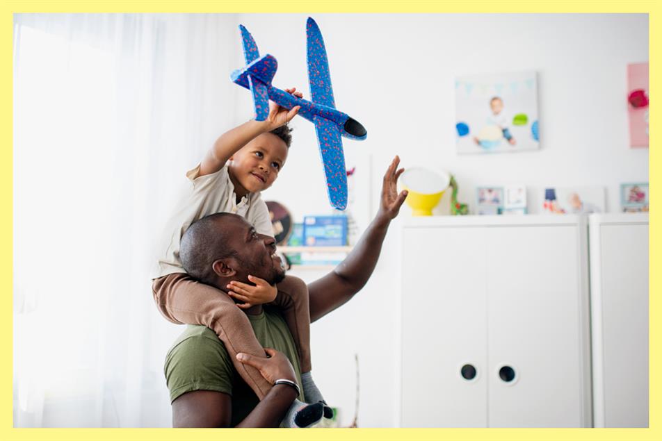 A father and son playing with a toy plane