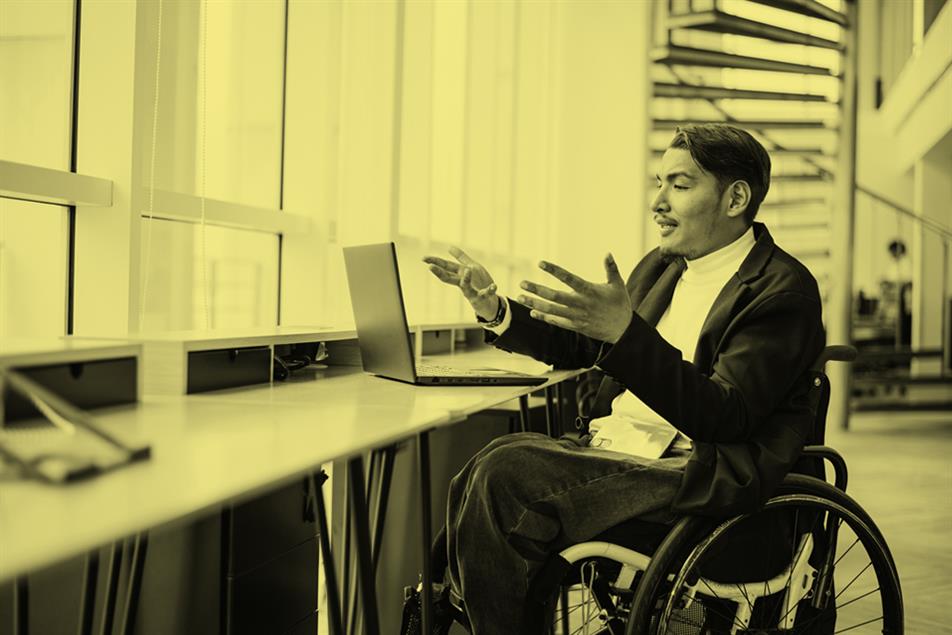 Person in a wheelchair in front of a laptop