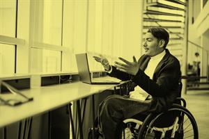 Person in a wheelchair in front of a laptop