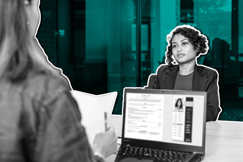 Two people sat opposite each other with a laptop