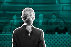 Person stood in front of group of people sat in a court