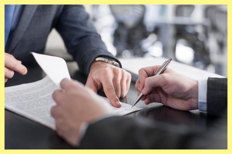 businessman showing client where to sign document 