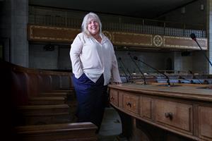 Deb Clarke from Manchester City Council stands in a meeting chamber
