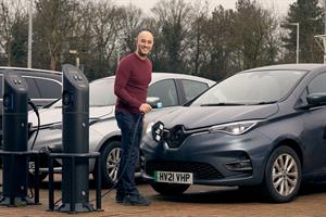 Smiling man at electric car charging point