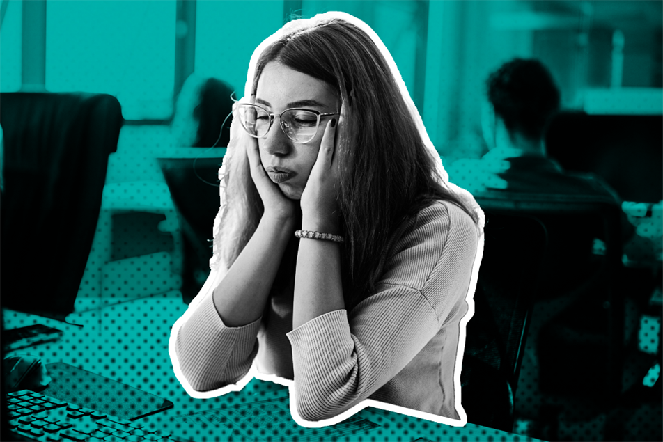 Person sat at a desk in an office with face leaning on their hands
