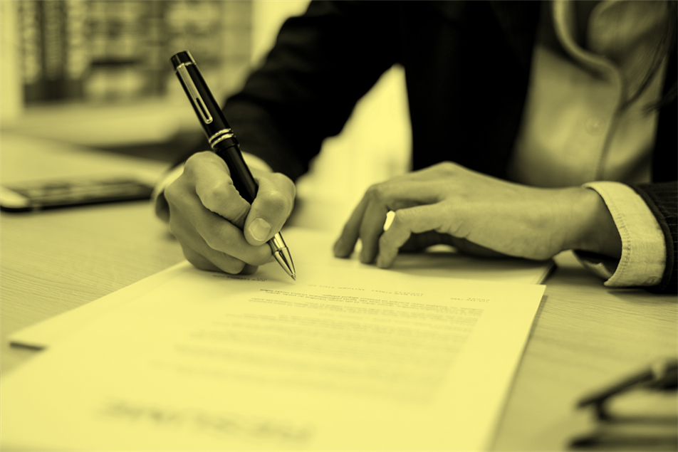 Close up of someone signing a document