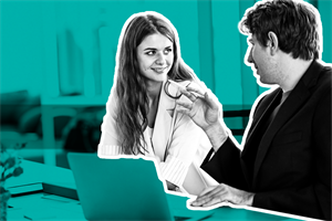 Two people at a desk smiling at each other