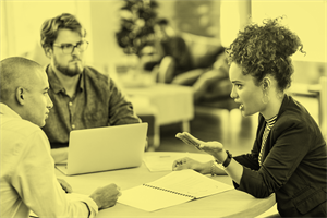 Group of people sat around a table talking