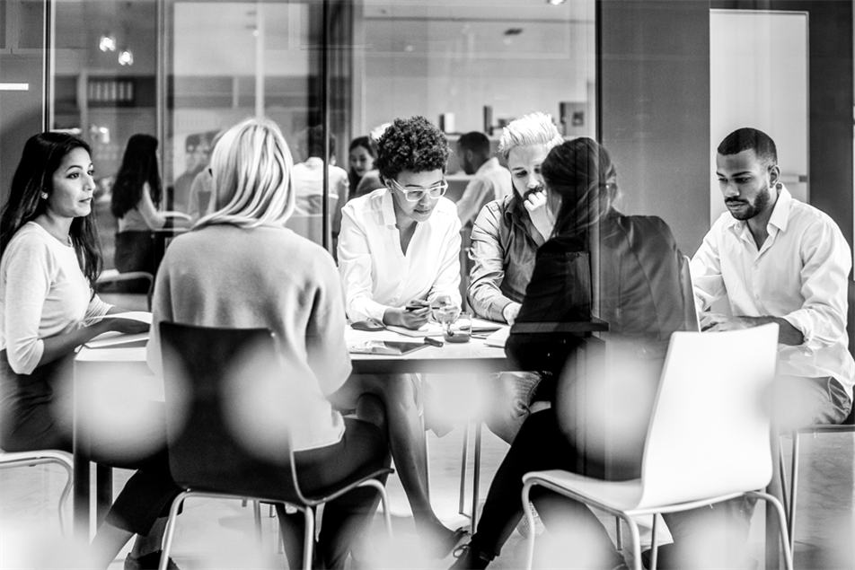 Group of people sat around a table in an office