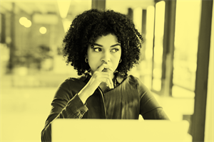 Person sat in front of a computer screen looking concerned