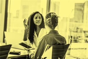 Two people sat talking in an office