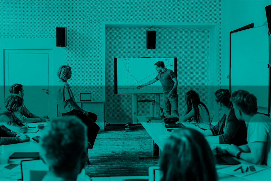 Group of people in a classroom watching someone presenting