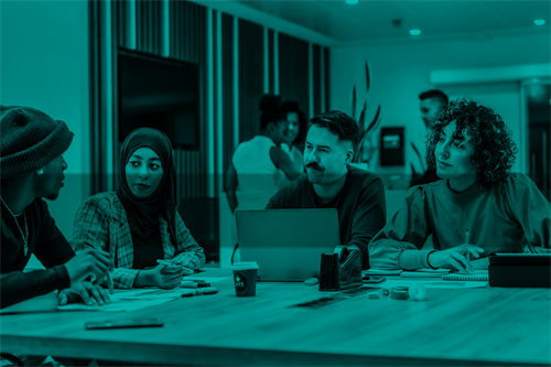 Group of people sat at a desk in an office