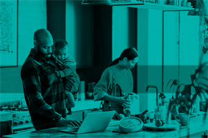 Man holding child while typing on laptop