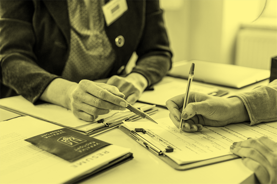 Close up of two people with a document and passport