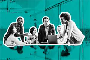 Group of people in an office gathered around a laptop