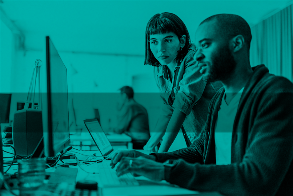 Two people looking at a computer screen in an office