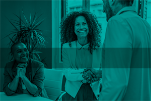 People smiling and shaking hands in an office