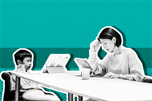 Woman and child sat at a table in front of a laptops