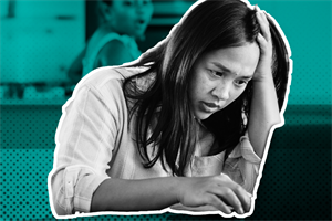 Person sat at a laptop with their hand on their head