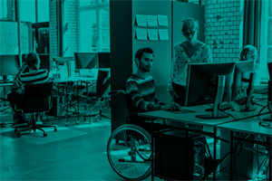 Person in a wheelchair using a computer in an office
